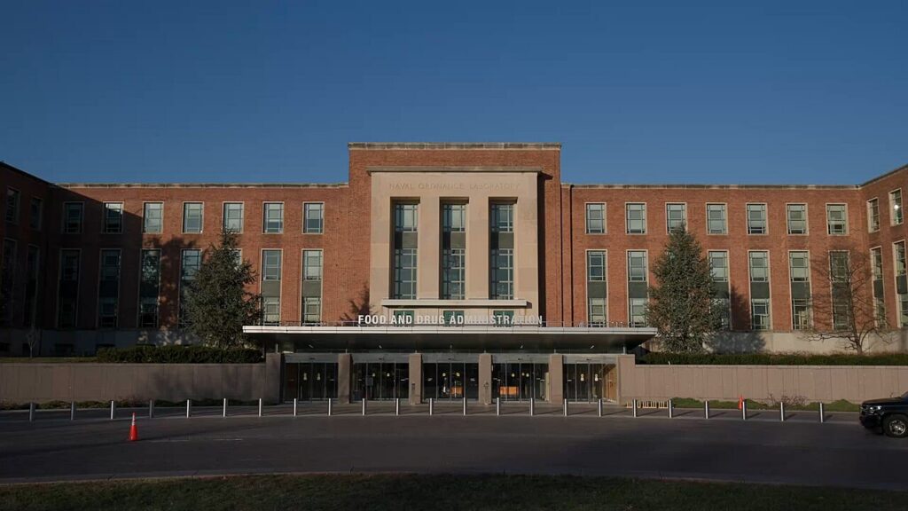 FDA building illuminated with colored lights at night, representing federal cosmetics oversight and MoCRA implementation.
