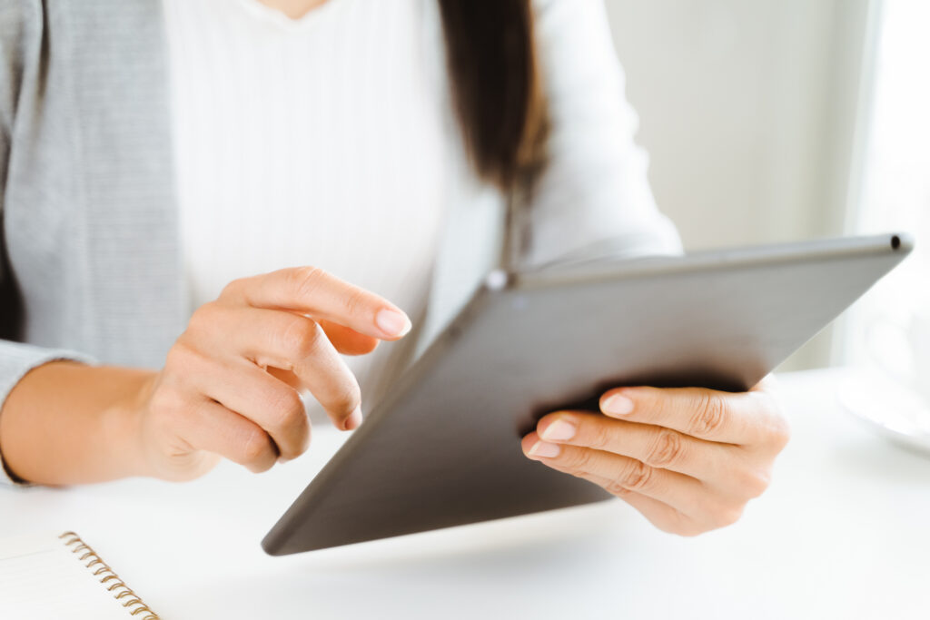 Close-up of a woman using a digital tablet in an office setting.