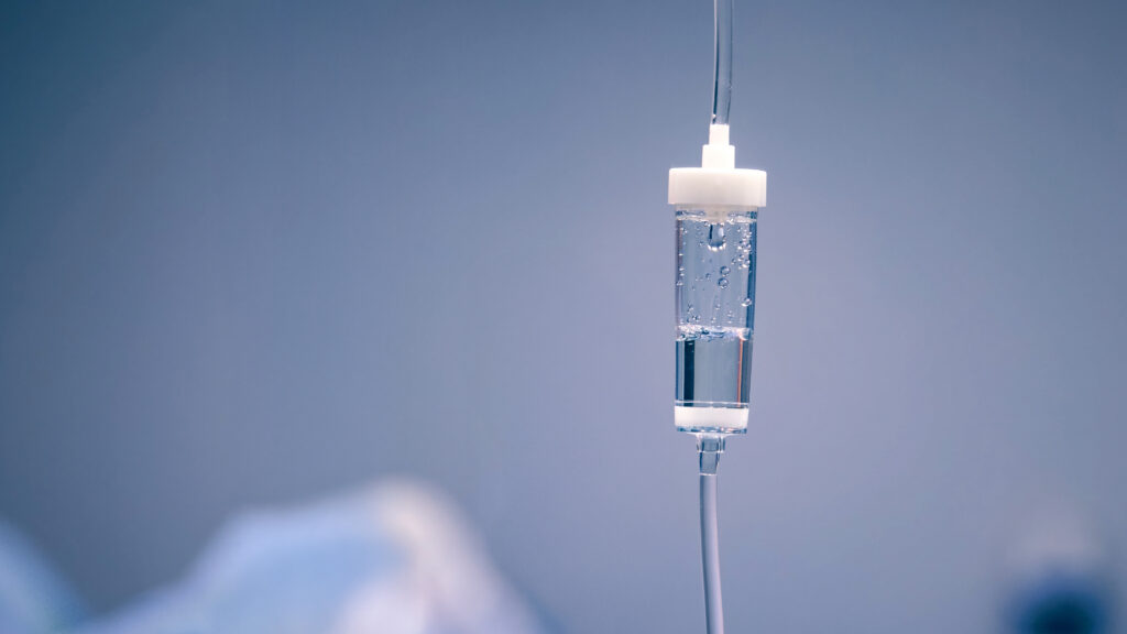 IV drip bag containing clear fluid in a clinical setting.